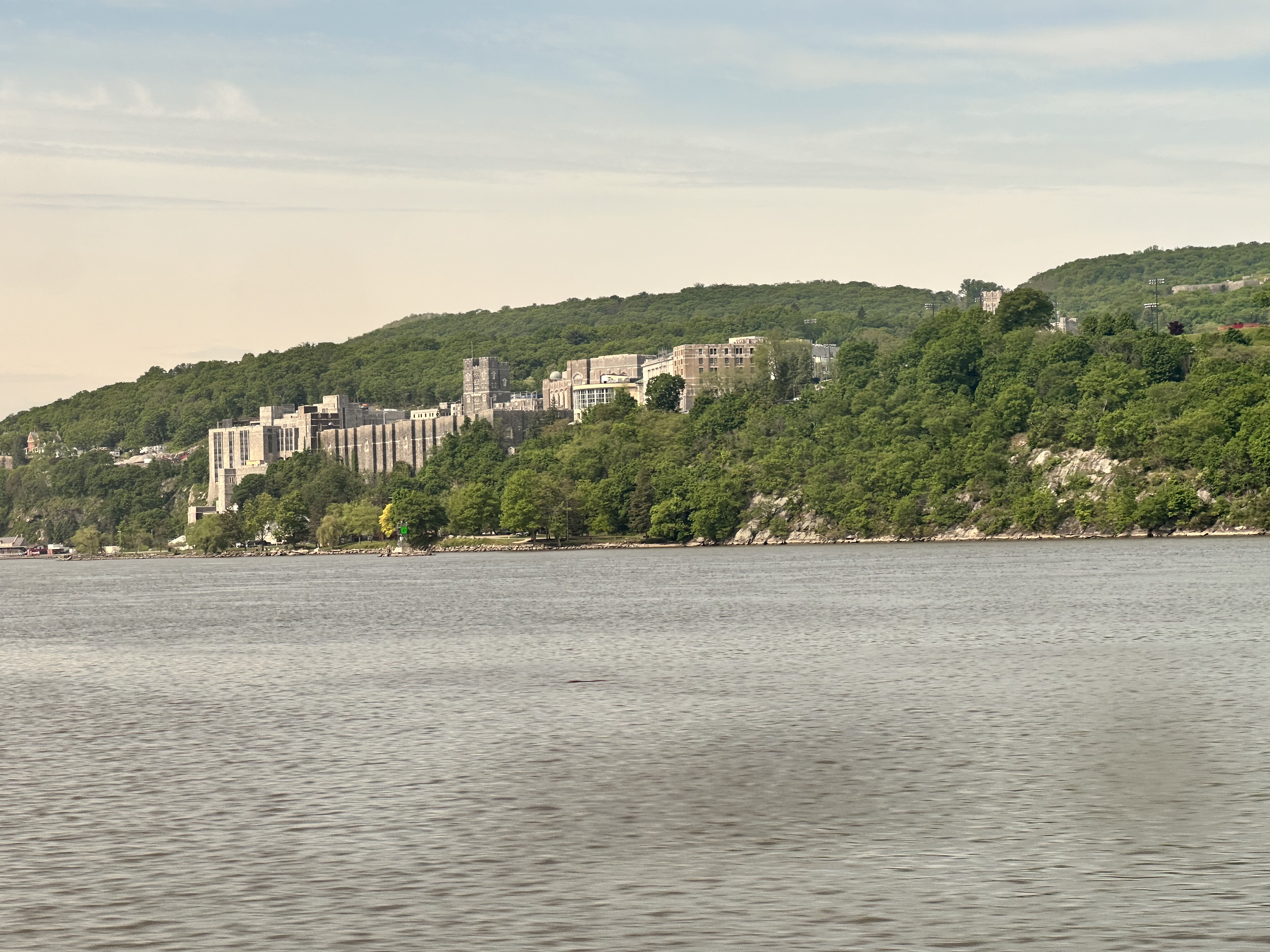 West Point military academy, a large collection of imposing stone buildings, 
            sits high on a cliff across the Hudson river from the train tracks